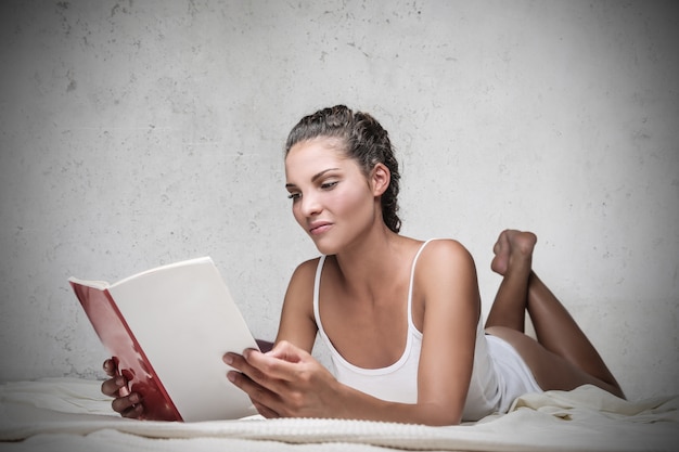 Hermosa mujer leyendo en la cama