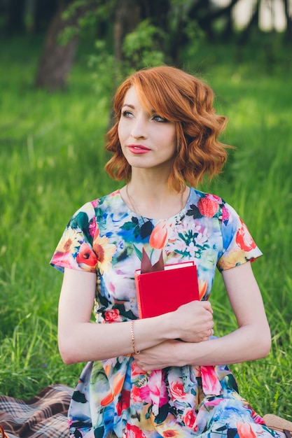 Hermosa mujer leyendo un libro en el jardín de primavera