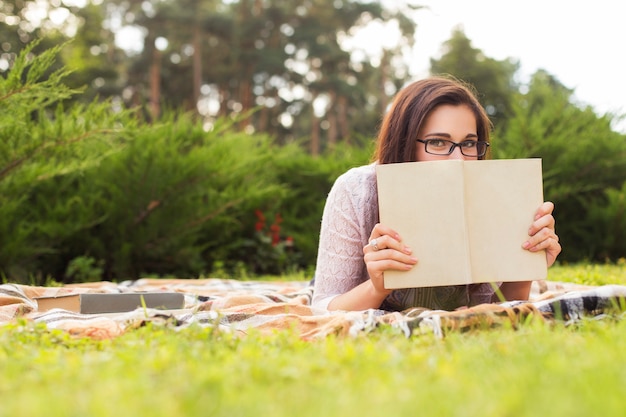 Hermosa mujer leyendo un libro en el parque