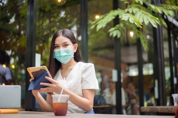 Hermosa mujer lleva mascarilla en cafetería