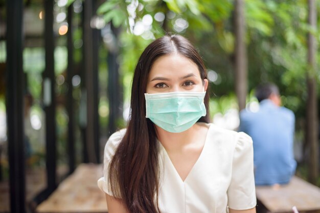 Hermosa mujer lleva mascarilla en cafetería