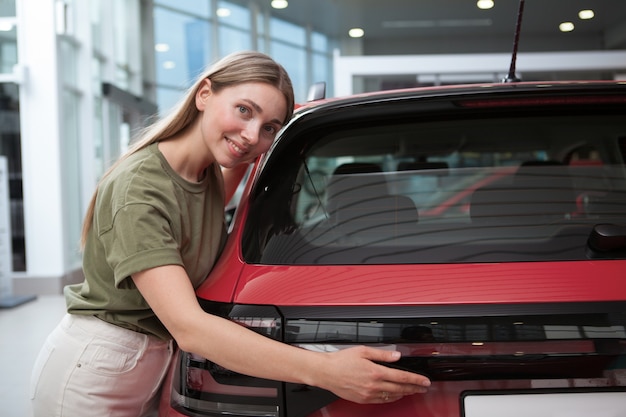 Hermosa mujer madura para compras de coche nuevo en el concesionario de automóviles