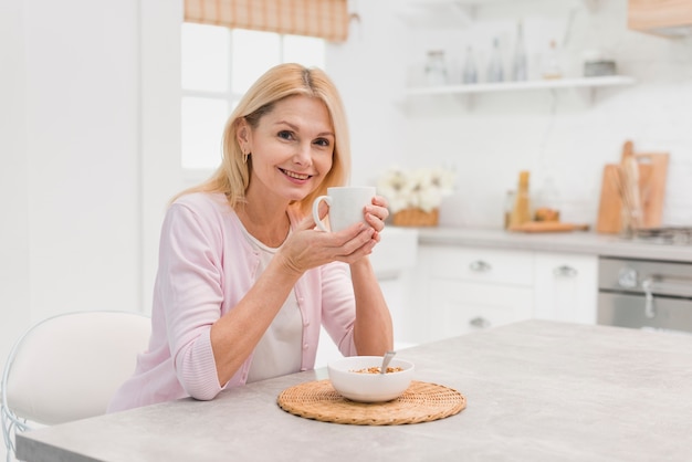 Foto hermosa mujer madura desayunando