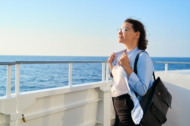 Hermosa mujer madura feliz en la cubierta del ferry disfrutando del viaje por mar
