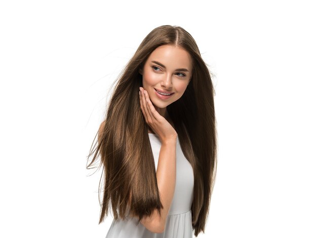 Hermosa mujer con las manos hermoso cabello largo y liso volador en vestido blanco aislado en blanco