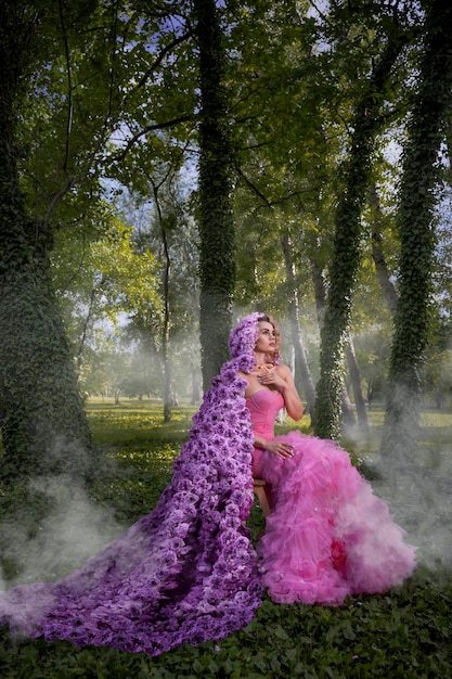 Hermosa mujer con manto de flores en el bosque de hiedra