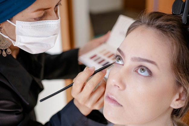 Hermosa mujer con maquillaje y lápiz labial en una exuberante mirada hermosa