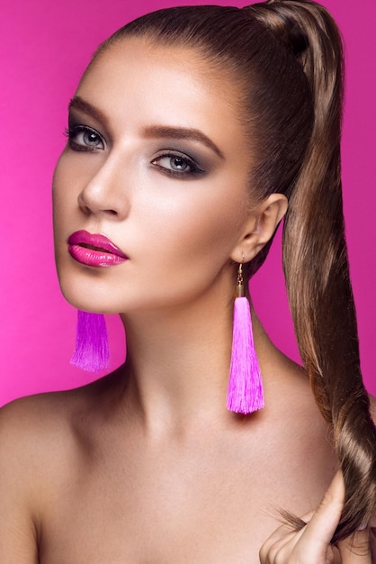 Hermosa mujer con maquillaje de noche accesorios brillantes y cabello largo y liso Ojos ahumados Fotografía de moda