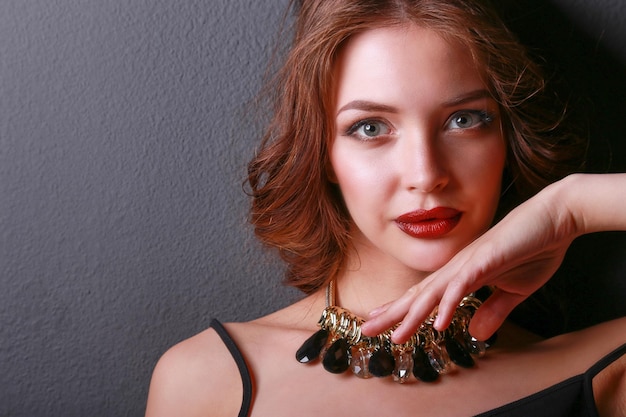 Hermosa mujer con maquillaje de noche en vestido negro