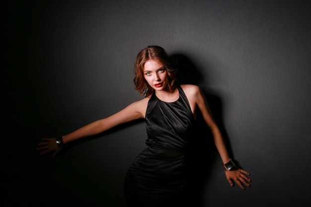 Hermosa mujer con maquillaje de noche en vestido negro