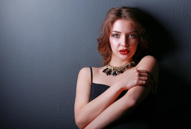 Hermosa mujer con maquillaje de noche en vestido negro