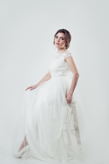 Hermosa mujer con maquillaje y peinado de novia con vestido blanco