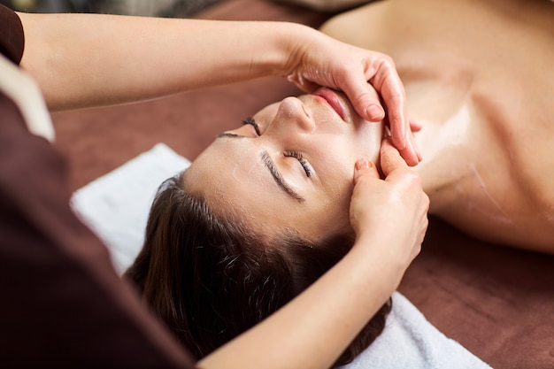 Hermosa mujer en un masaje facial en un salón de spa.