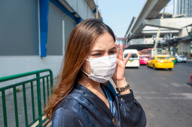 Hermosa mujer con máscara antipolvo protege la contaminación del aire y el coronavirus