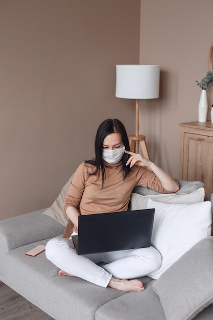 Hermosa mujer con máscara protectora trabajando desde su oficina en casa