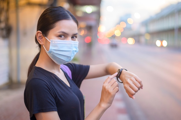 Hermosa mujer con una máscara quirúrgica al aire libre, covid-19, concepto de salud y contaminación.