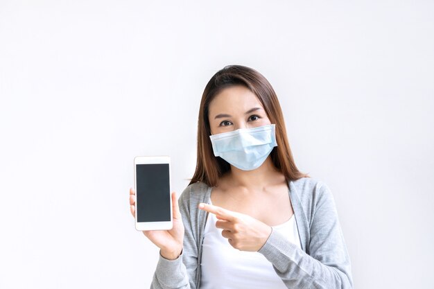 Hermosa mujer con mascarilla médica con smartphone para espacio de copia