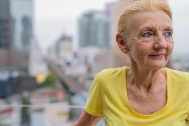 Hermosa mujer mayor pensando al aire libre en la ciudad