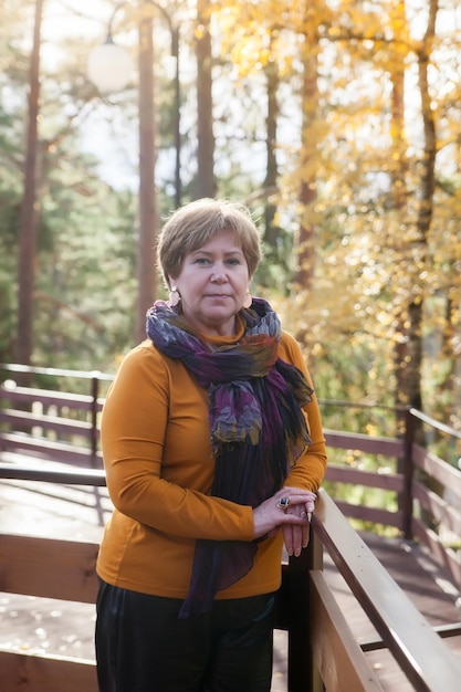 Hermosa mujer de mediana edad bien arreglada en un bosque de pinosxDxA