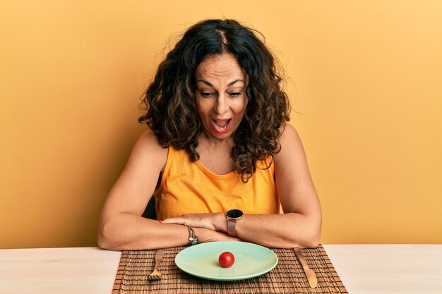 Hermosa mujer de mediana edad a dieta celebrando loca y sorprendida por el éxito con los ojos abiertos gritando emocionada.