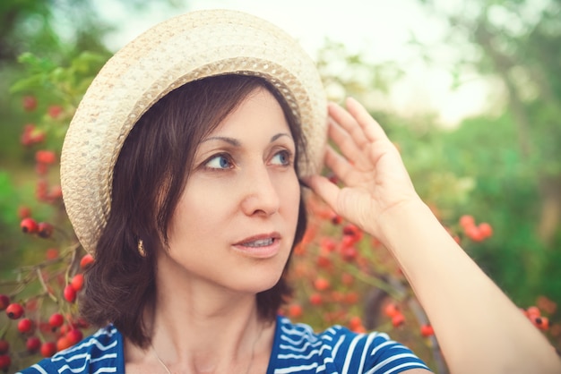 Hermosa mujer de mediana edad con sombrero de paja sonriendo