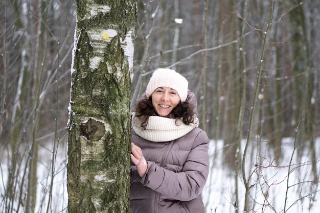 Foto hermosa mujer de mediana edad sonriente en el invierno al aire libre. concepto de invierno