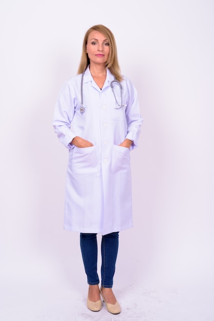 Hermosa mujer médico con cabello rubio contra el espacio en blanco