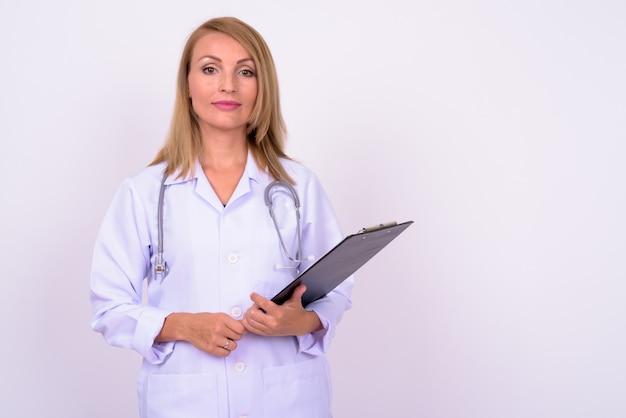 Hermosa mujer médico con cabello rubio contra el espacio en blanco