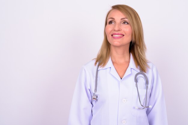 Hermosa mujer médico con cabello rubio contra el espacio en blanco