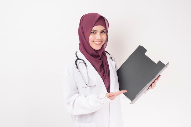 Hermosa mujer médico con hijab, sosteniendo portapapeles