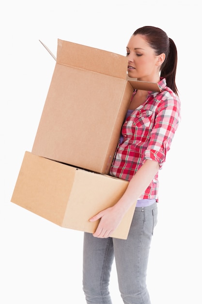 Foto hermosa mujer mirando dentro de una caja de cartón mientras está de pie