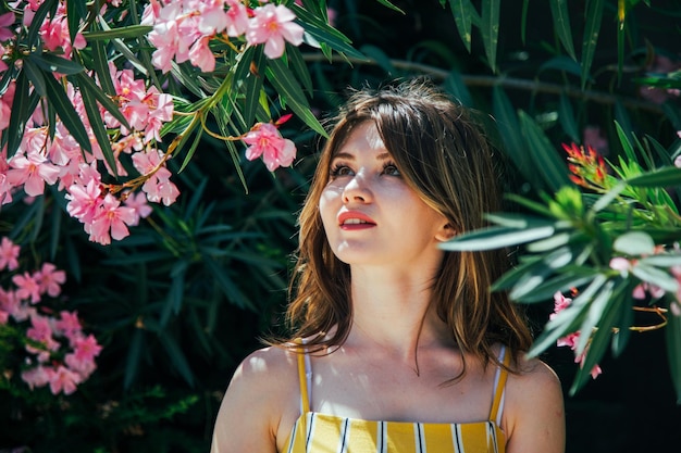 Hermosa mujer mirando flores de color púrpura