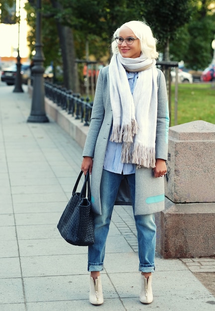 Hermosa mujer de moda de pie en la calle de la ciudad. Día de otoño.