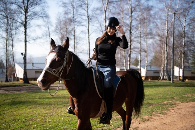 Hermosa mujer monta un caballo con casco