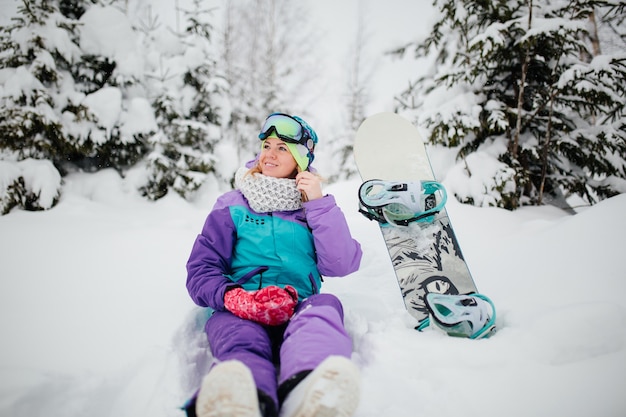 hermosa mujer en la montaña en snowboard