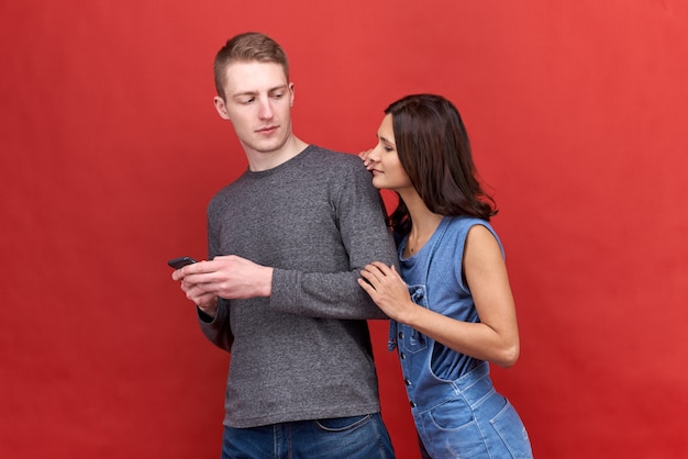 Hermosa mujer morena ardiente mira incrédulamente espiando para llamar a su novio.