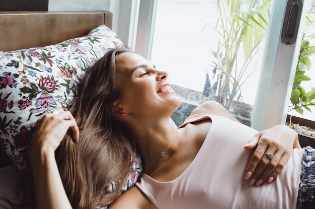 Hermosa mujer morena en casa loft en ubicación tropical.