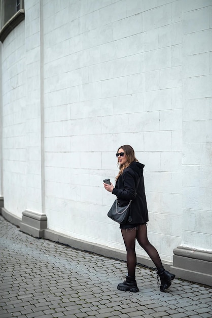 Hermosa mujer morena con una figura hermosa bellamente vestida camina en la ciudad de otoño. Concepto de ciudad. Concepto de otoño.