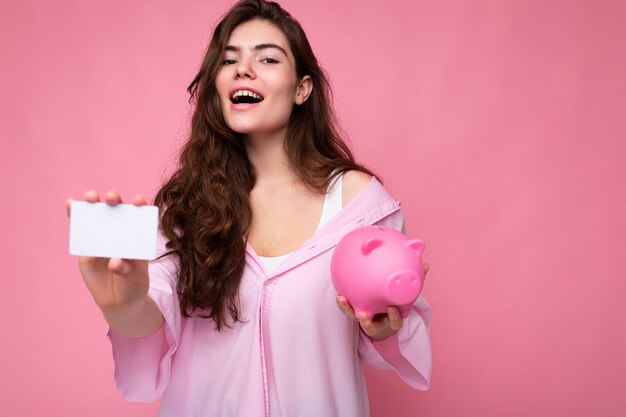 Hermosa mujer morena joven alegre feliz con camisa aislada sobre fondo rosa con gratis