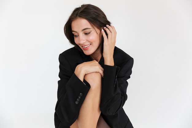 Hermosa mujer morena joven sonriente con chaqueta de gran tamaño posando aislado