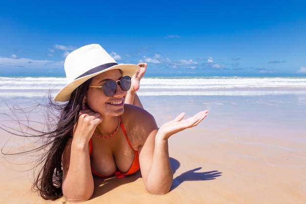 Hermosa mujer morena en la playa con espacio de copia