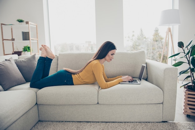 Hermosa mujer morena posando en el interior con su computadora portátil