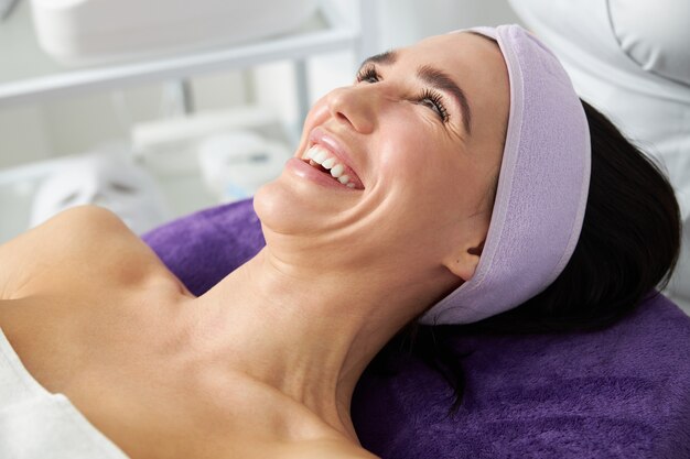 Foto hermosa mujer morena sonriente en gabinete de cosmetología