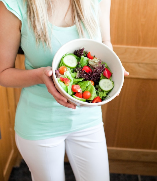 Hermosa mujer mostrando una ensalada