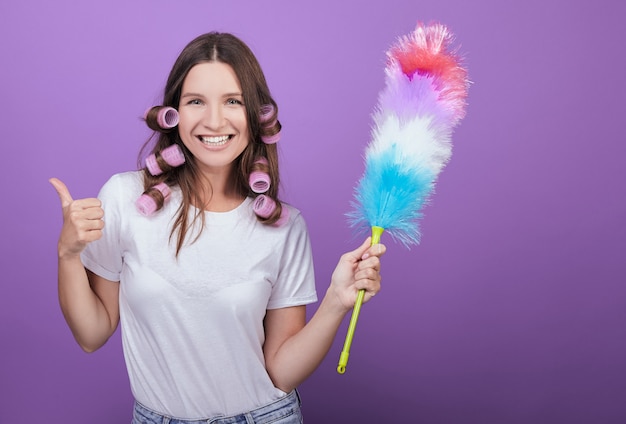 Hermosa mujer muestra un signo de super durante la limpieza.