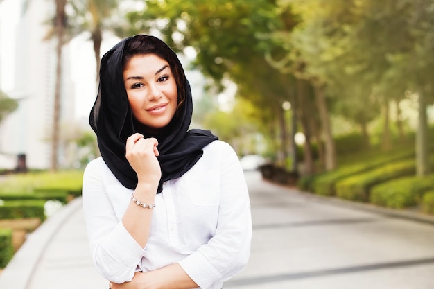 Hermosa mujer musulmana de carrera mixta en una calle de la ciudad de Dubai