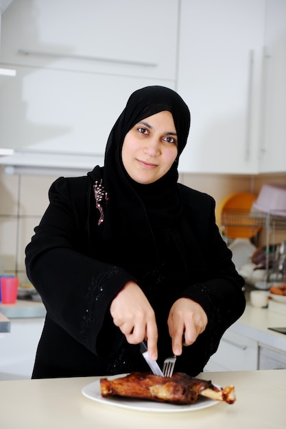 Hermosa mujer musulmana en la cocina