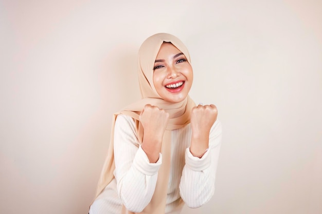 Hermosa mujer musulmana entusiasta celebrando el concepto de éxito sí