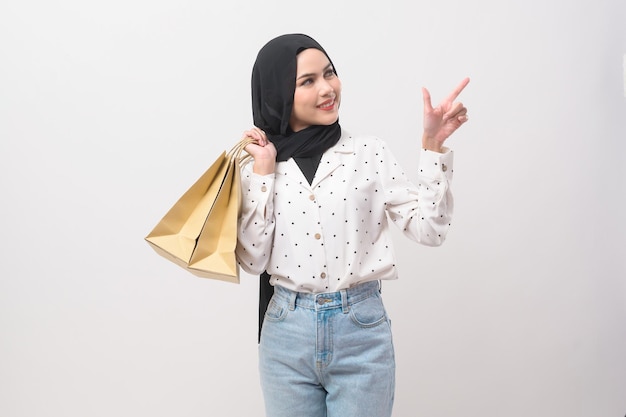 Hermosa mujer musulmana con hiyab con tarjeta de crédito y bolsa de compras
