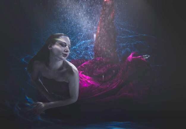 Hermosa mujer nadando con disfraces bajo el agua